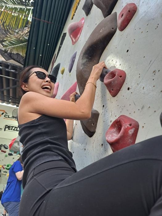 Woman wearing No Se sunglasses rock climbing
