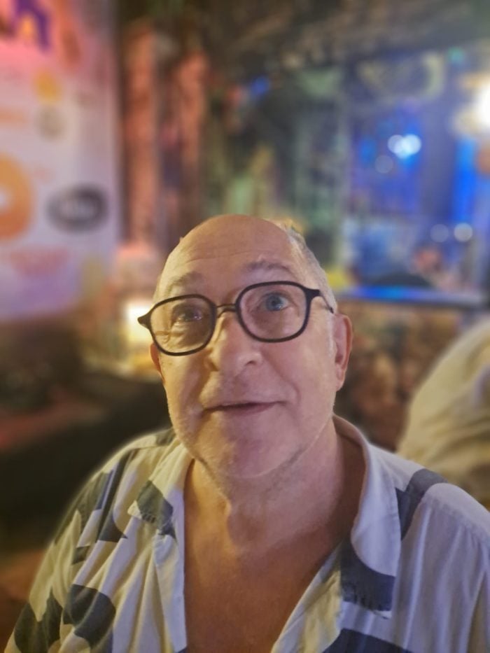 Man wearing glasses at an evening gathering